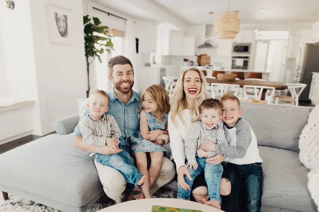 familie som sitter pรฅ en sofa med ullputer og puter