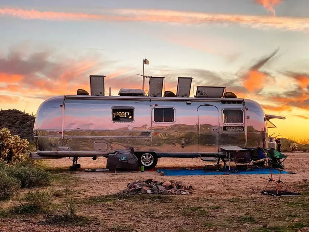 glรคnsande husbil med solnedgรฅngen i bakgrunden
