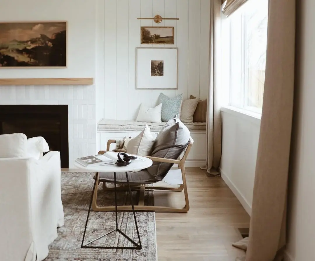 mysigt minimalistiskt vardagsrum med stol, bänk, kuddar och konst