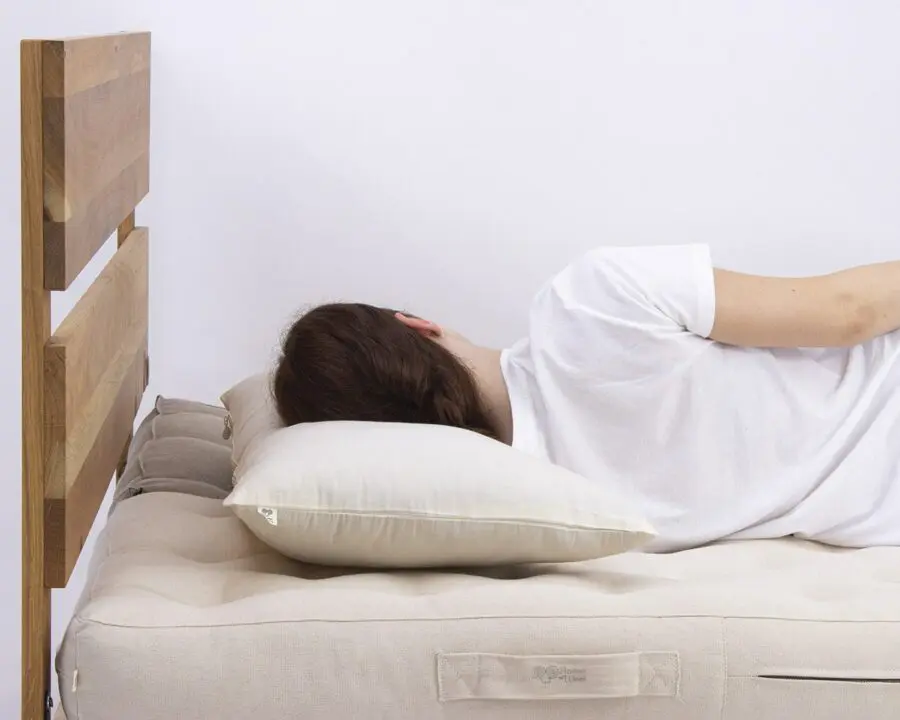 malli, joka nukkuu kaarevalla kylkiunille tarkoitetulla tyynyllä - sivulta katsottuna.