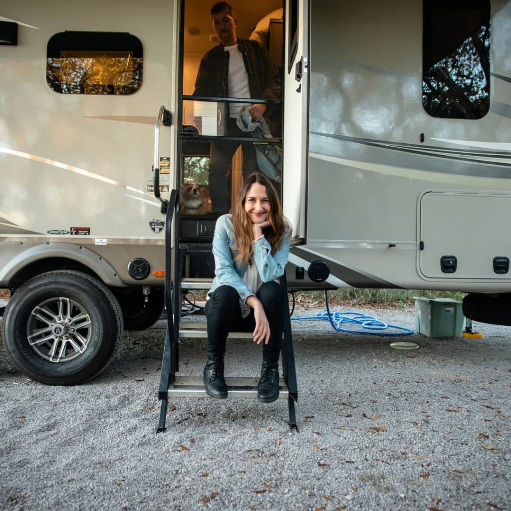man and woman standing at the door of an rv