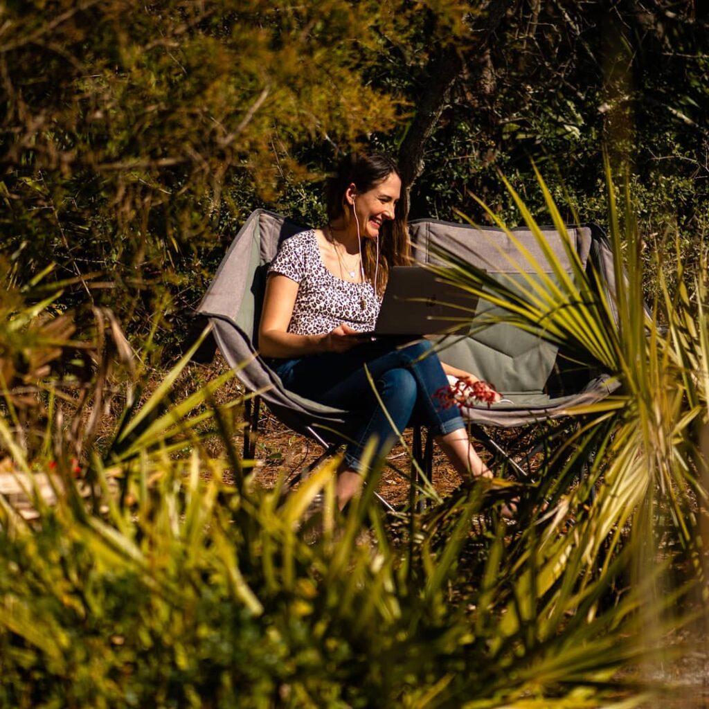 woman sitting on a woldable chair in nature