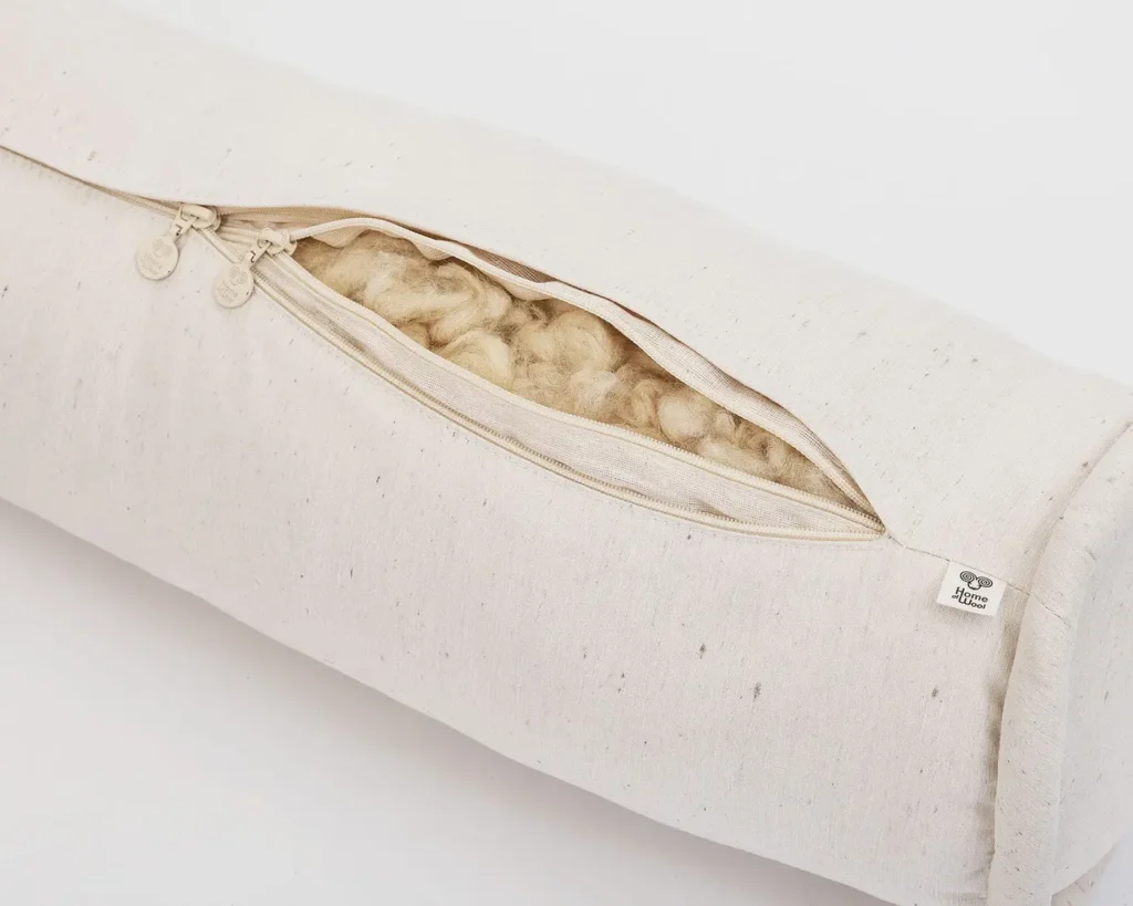 Cuscino cilindrico in lana con fodera apribile che rivela l'imbottitura