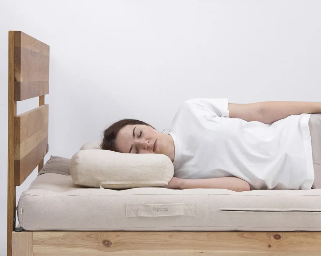 donna che dorme su un letto con un cuscino per chi dorme di lato