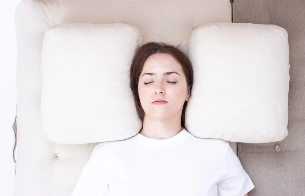Donna che dorme su un materasso di lana con un cuscino per chi dorme sulla schiena.