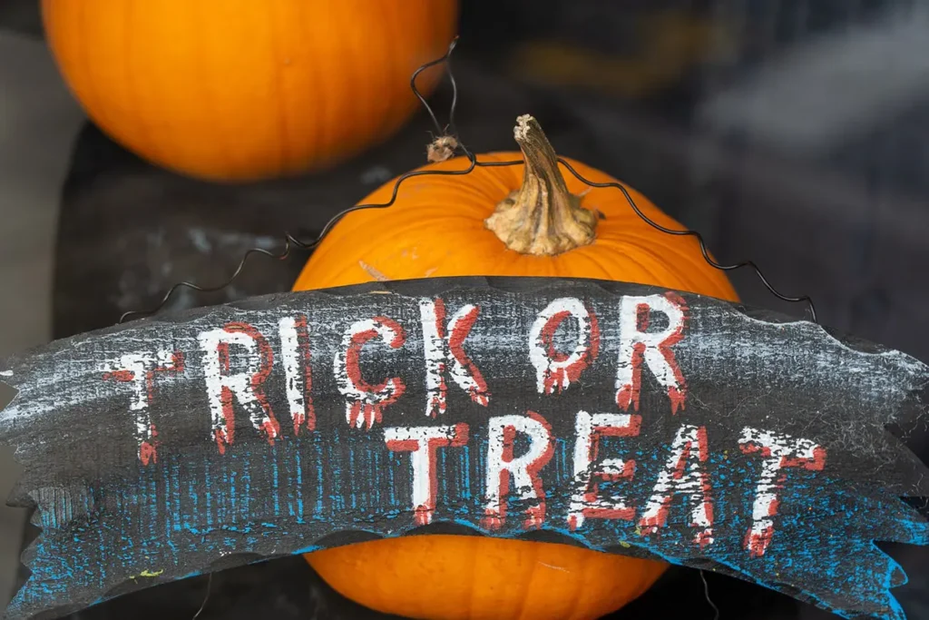 trick or treat-bord met pompoenen op de achtergrond