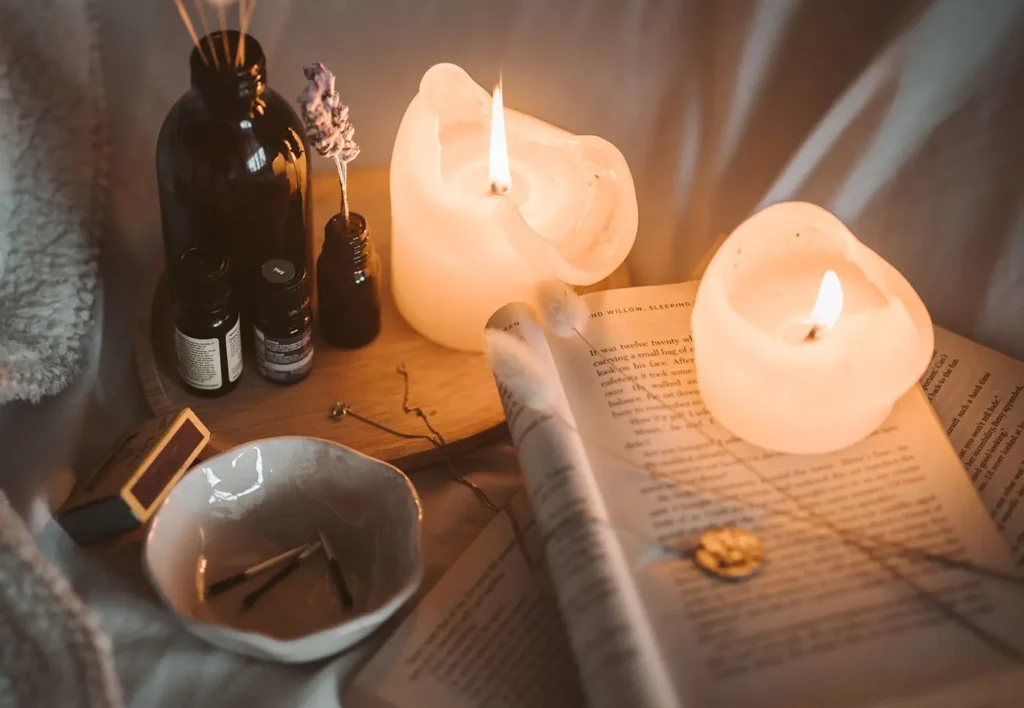 cozy scene with candles, book, oils and matches