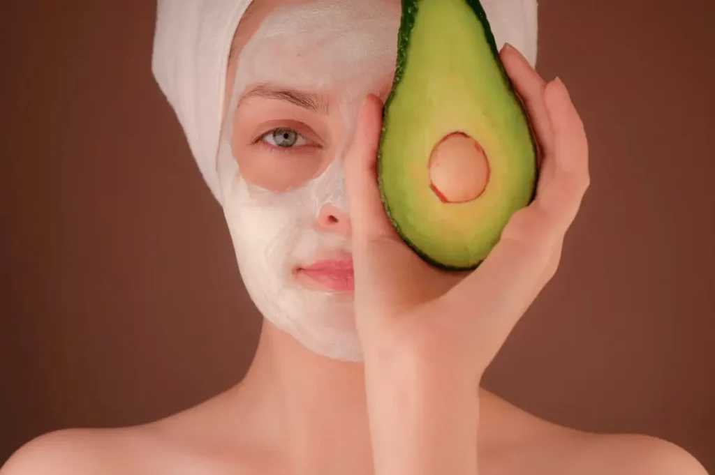 woman with a face mask holding an avocado