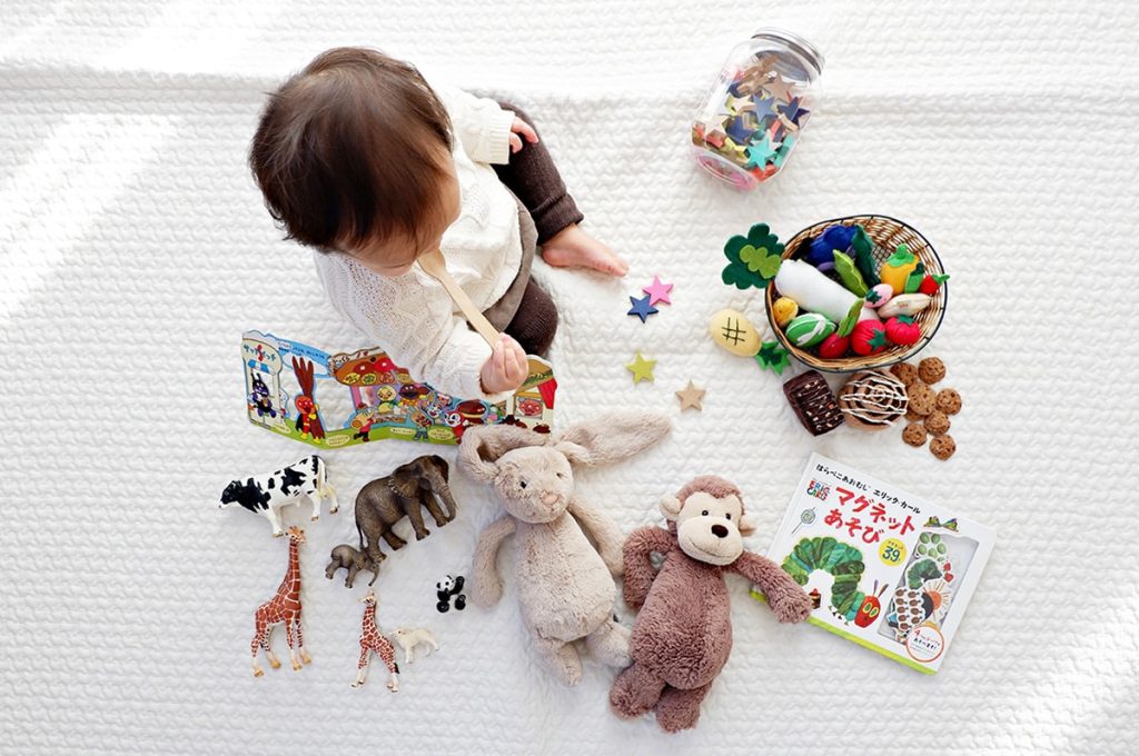 Kind spielt auf dem Boden mit Spielzeug
