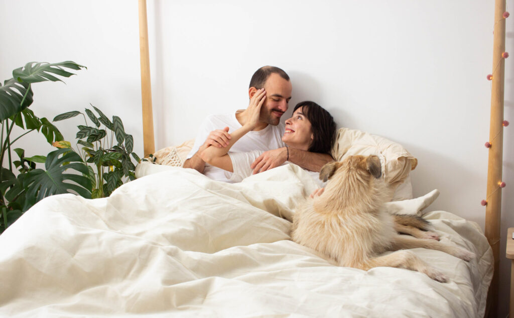 homme et femme au lit avec un chien