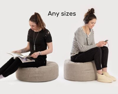 Home of Wool Round Ottoman with Flat Sides with model sitting on it