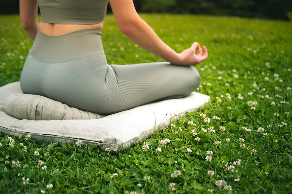 woman doing yoga on a home of wool cushion