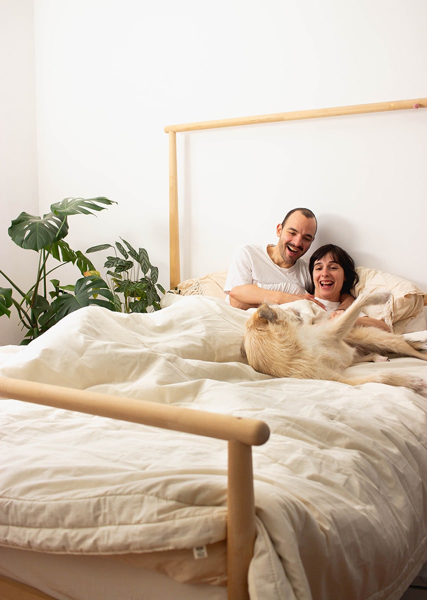 Coppia a letto con cane, coperta dal piumino di lana Couples'