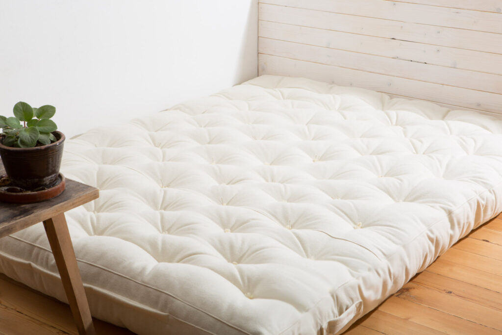 hem med ullmadrass på trägolv