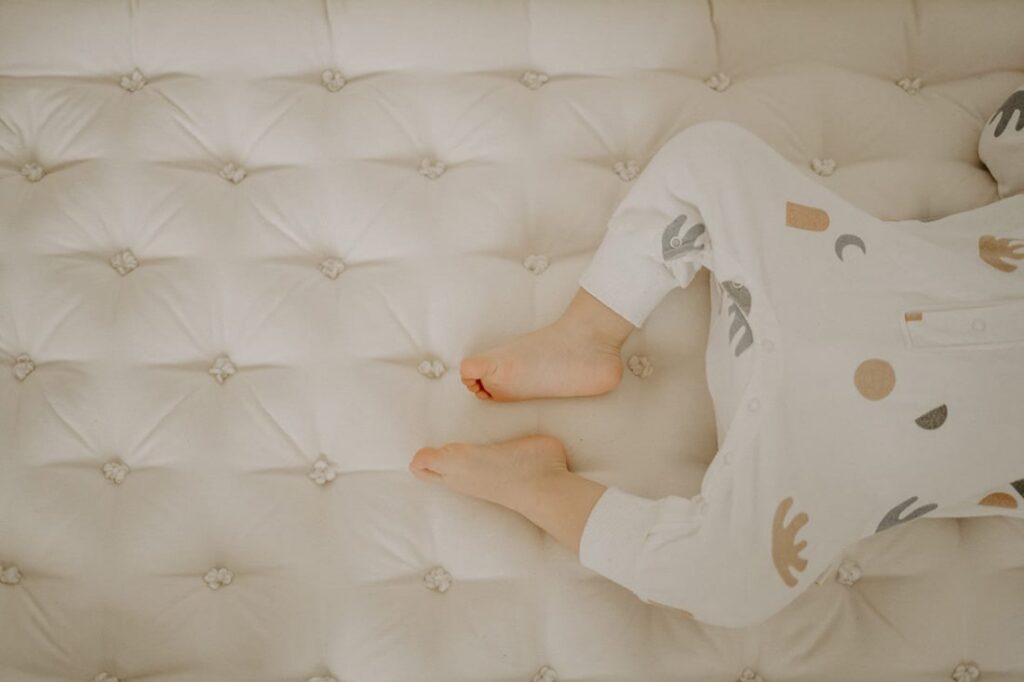 baby som ligger på en madrass av ull