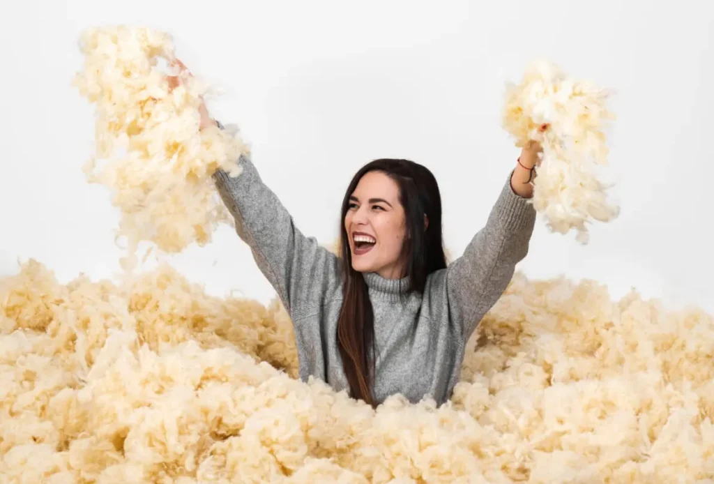 happy woman in a pile of wool