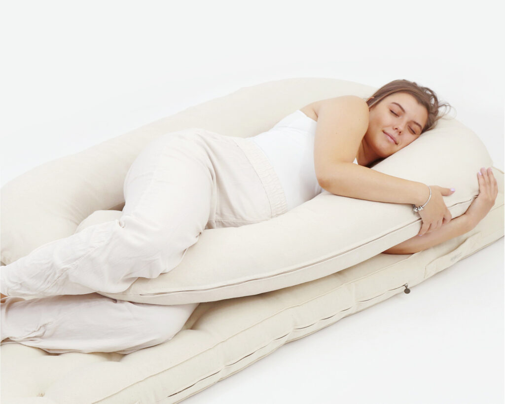 pregnant woman hugging a home of wool body pillow