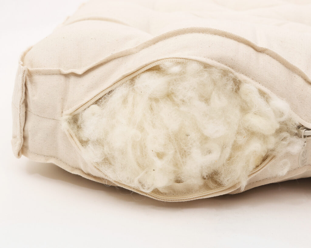 unzipped wool mattress revealing natural wool filling inside