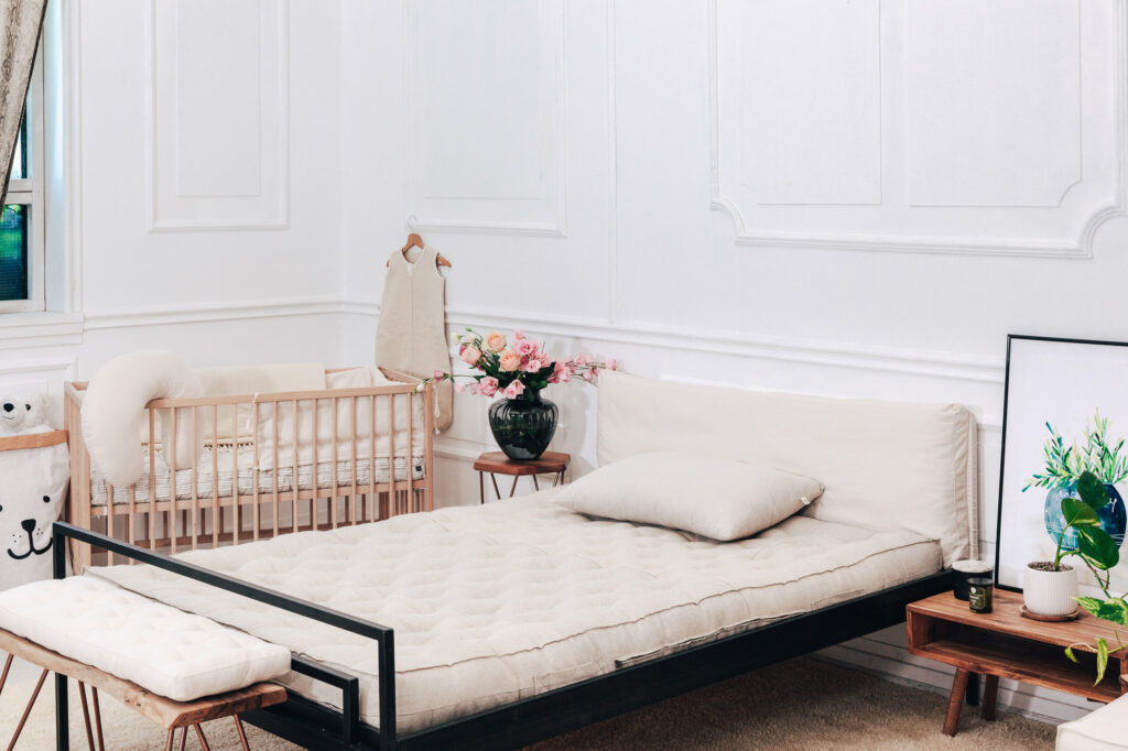 bed with a home of wool mattress next to a crib bed with wool products