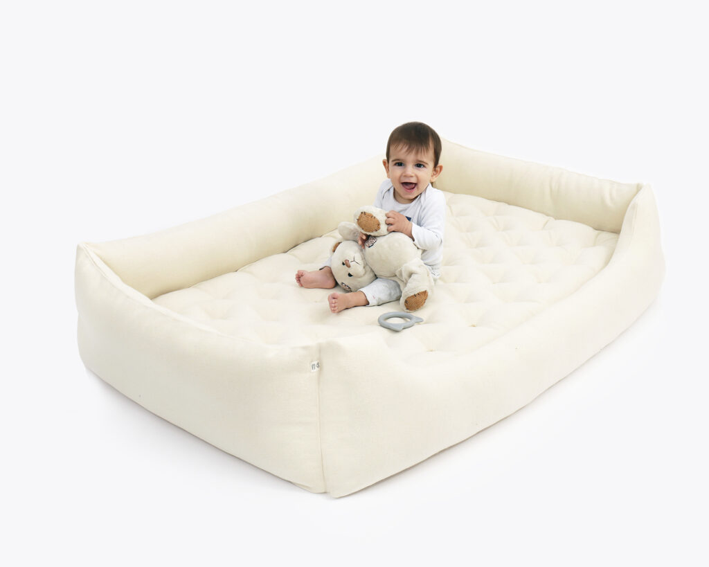 enfant en bas âge dans une maison avec lit Montessori en laine au sol