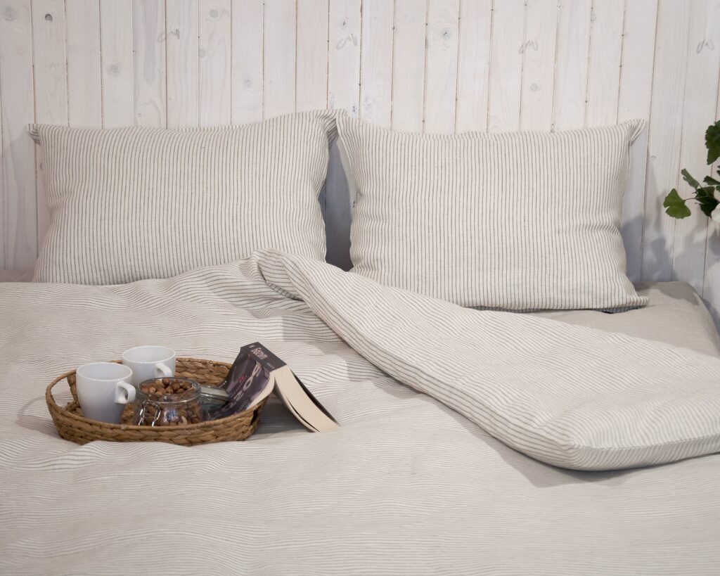 inbjudande randiga linne-sängkläder mot trävägg