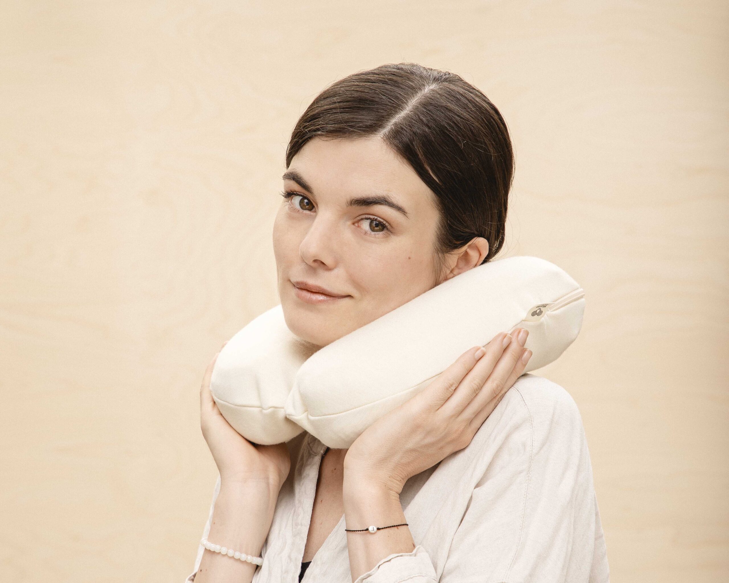 leende kvinna med en resekudde i ull runt halsen