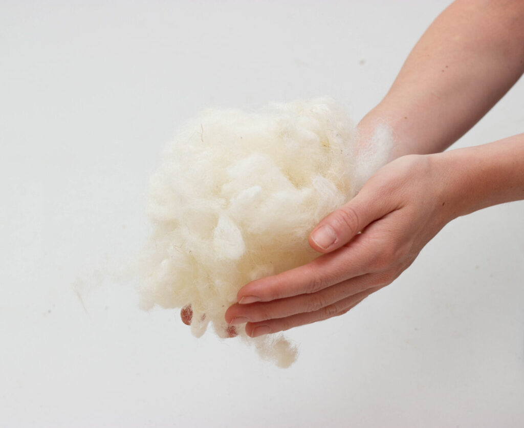 hænder, der holder uldfyld