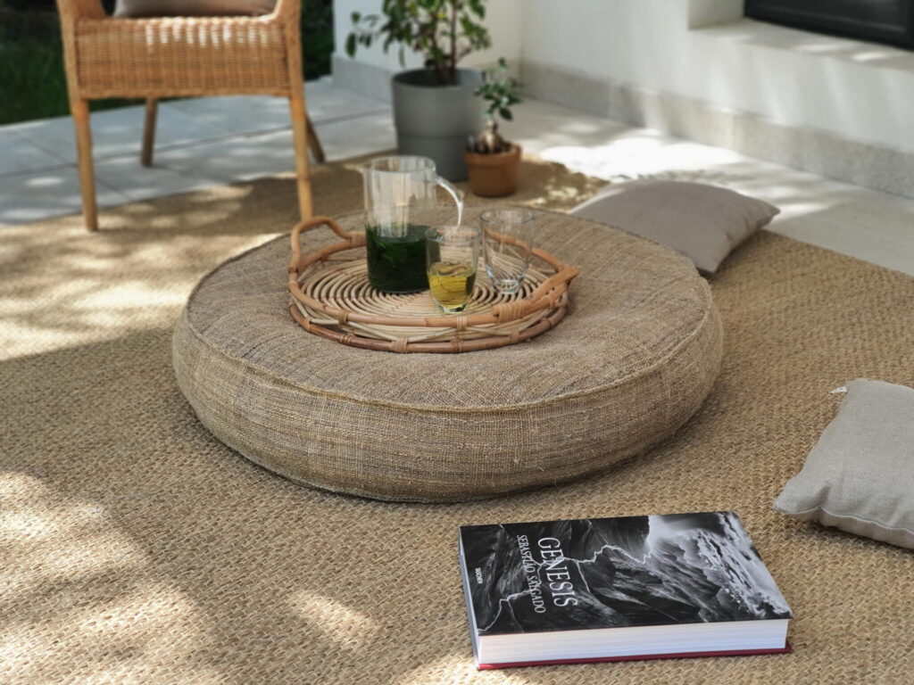 gezellige setting met een ronde wollen tafel, drankjes, kussens en zachte verlichting