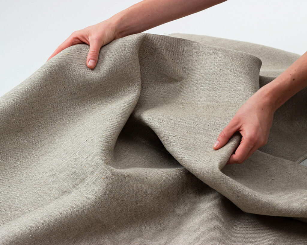 hands holding 100% linen fabric