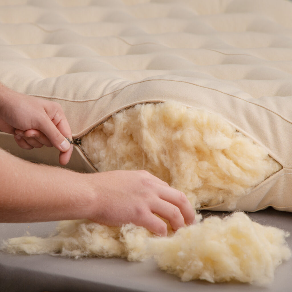 wool stuffing being put into a mattress