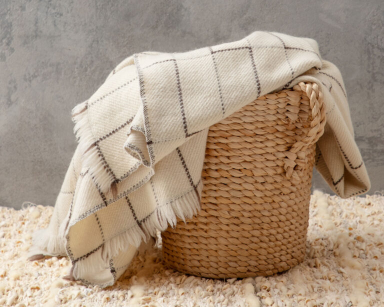 heritage wool blanket in a woven basket on top of a zero waste rug
