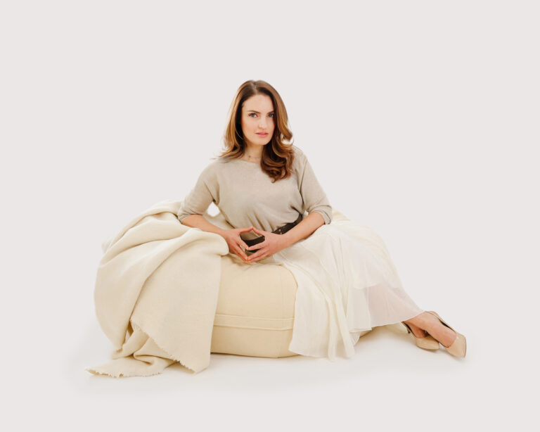 Puf grande de lana con una mujer sentada encima.