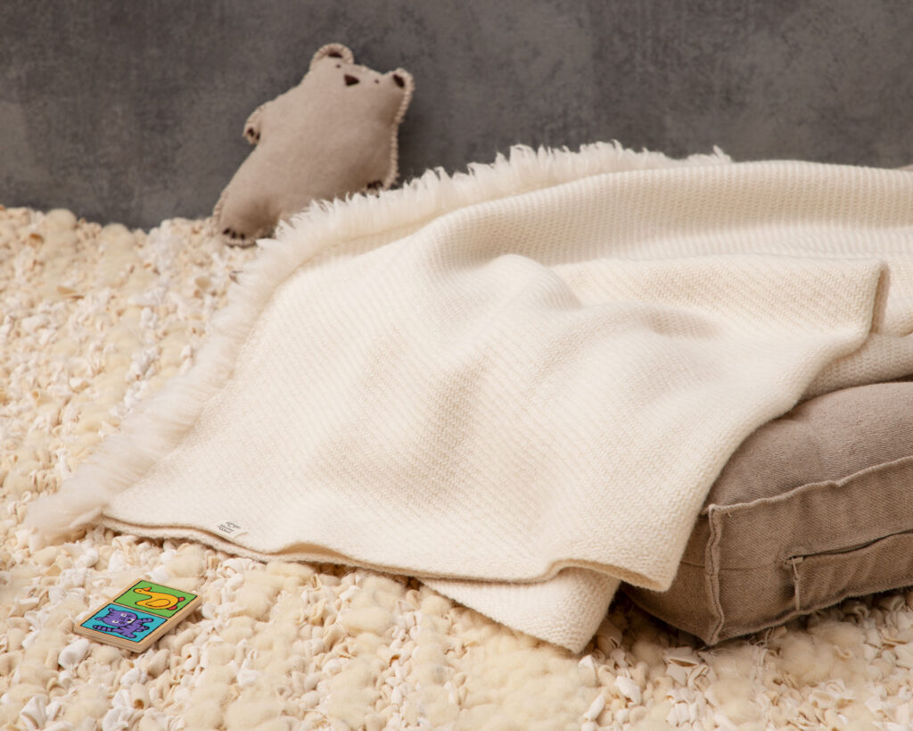 home of wool merino baby blanket on handwoven rug