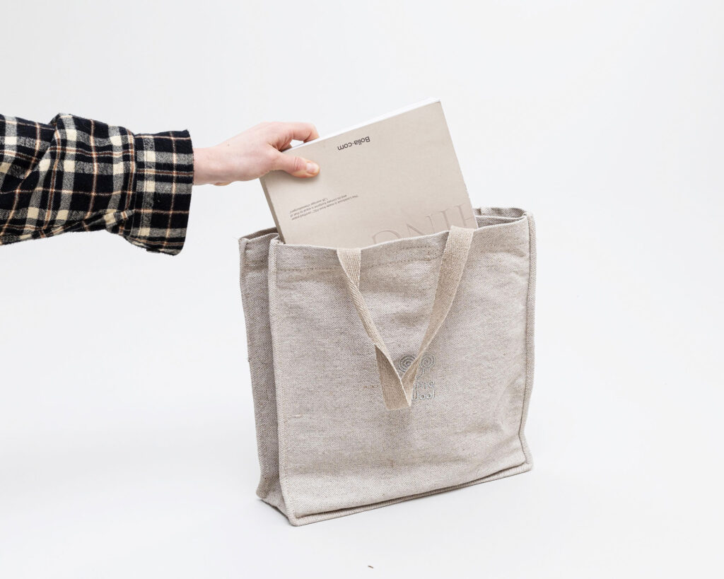 hånd lægger bog i uld taske