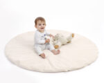 bébé jouant sur un tapis de jeu rond en laine