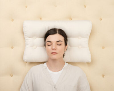 wool ergonomic pillow with a person sleeping on it, on a wool mattress
