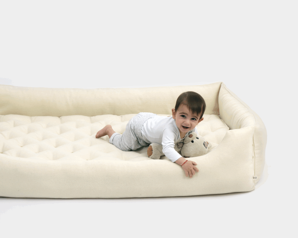 Lit Montessori en laine avec un enfant dedans
