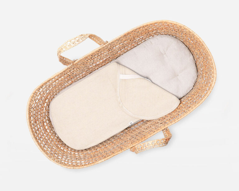 wool moses basket mattress in a basket with a protector