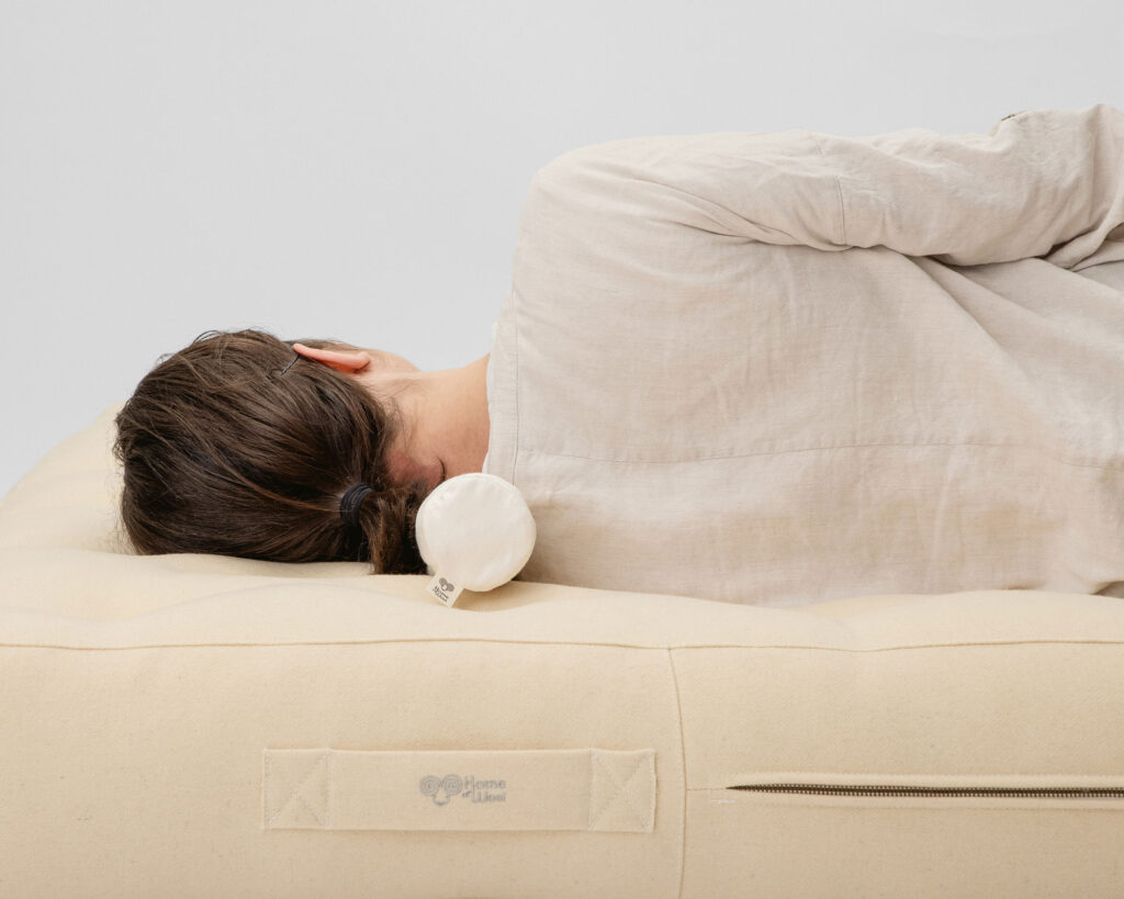 wool neck roll pillow on a wool mattress