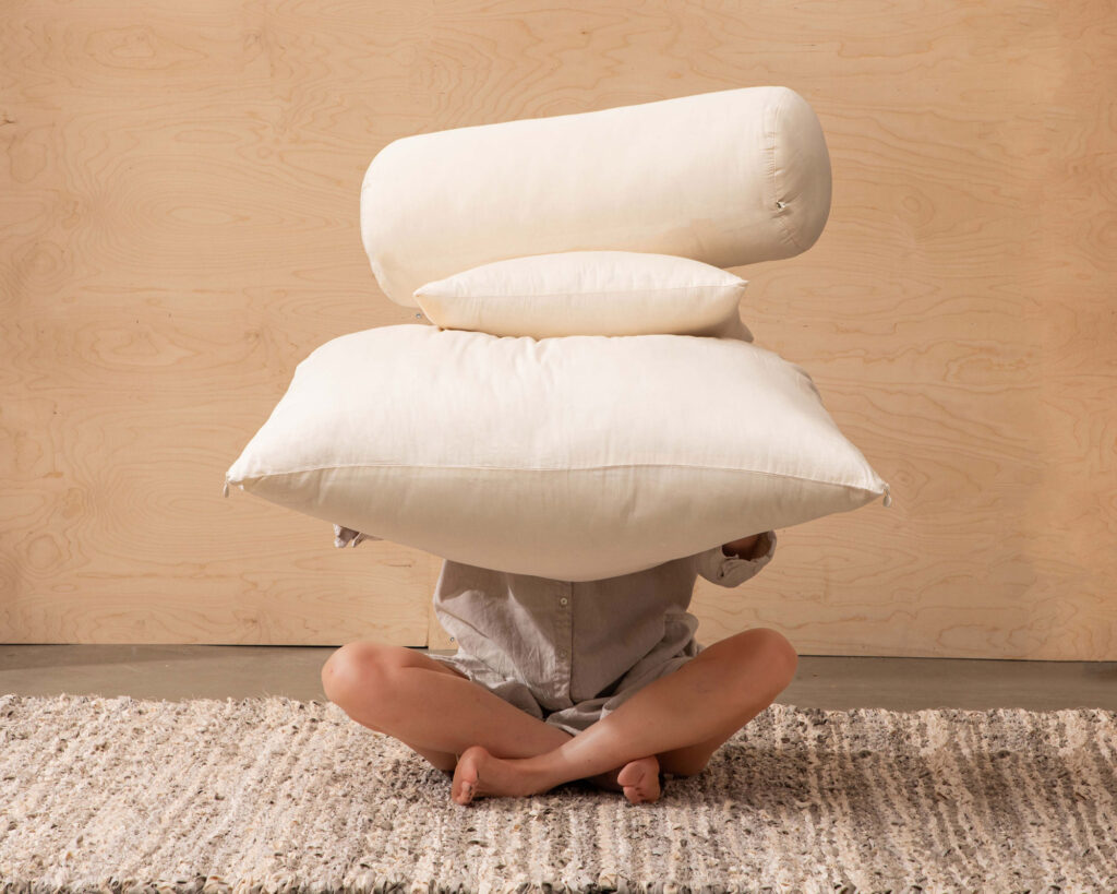 a person holding different shaped pillows with wool filling