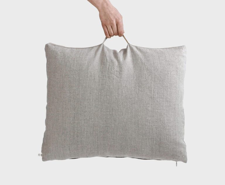 Wool travel pillow being held by the handle