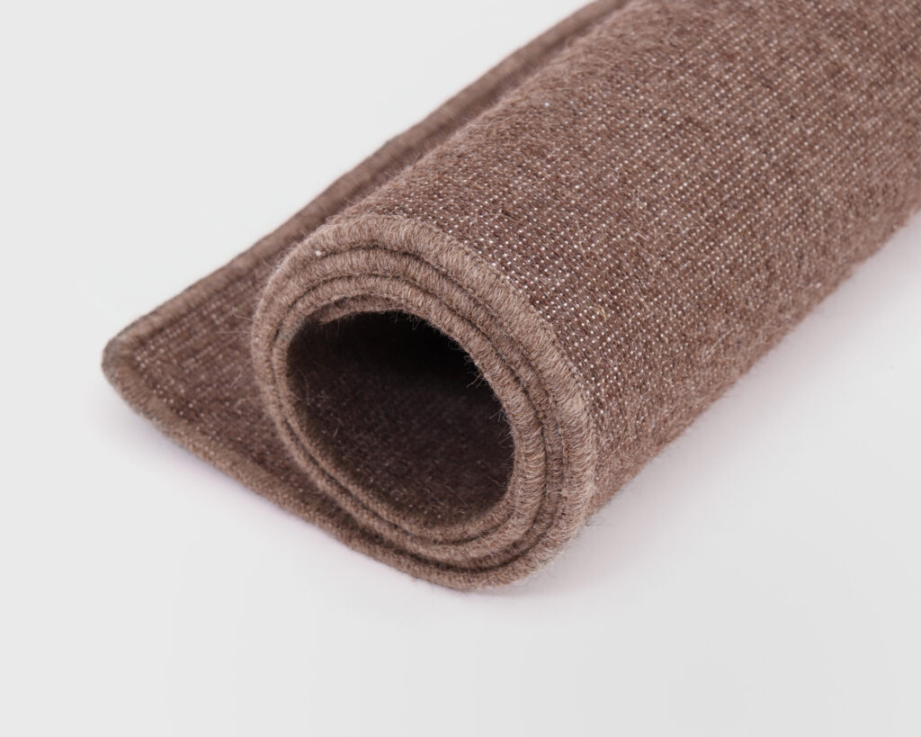 Dunkelbraune Yogamatte aus Wolle, aufgerollt