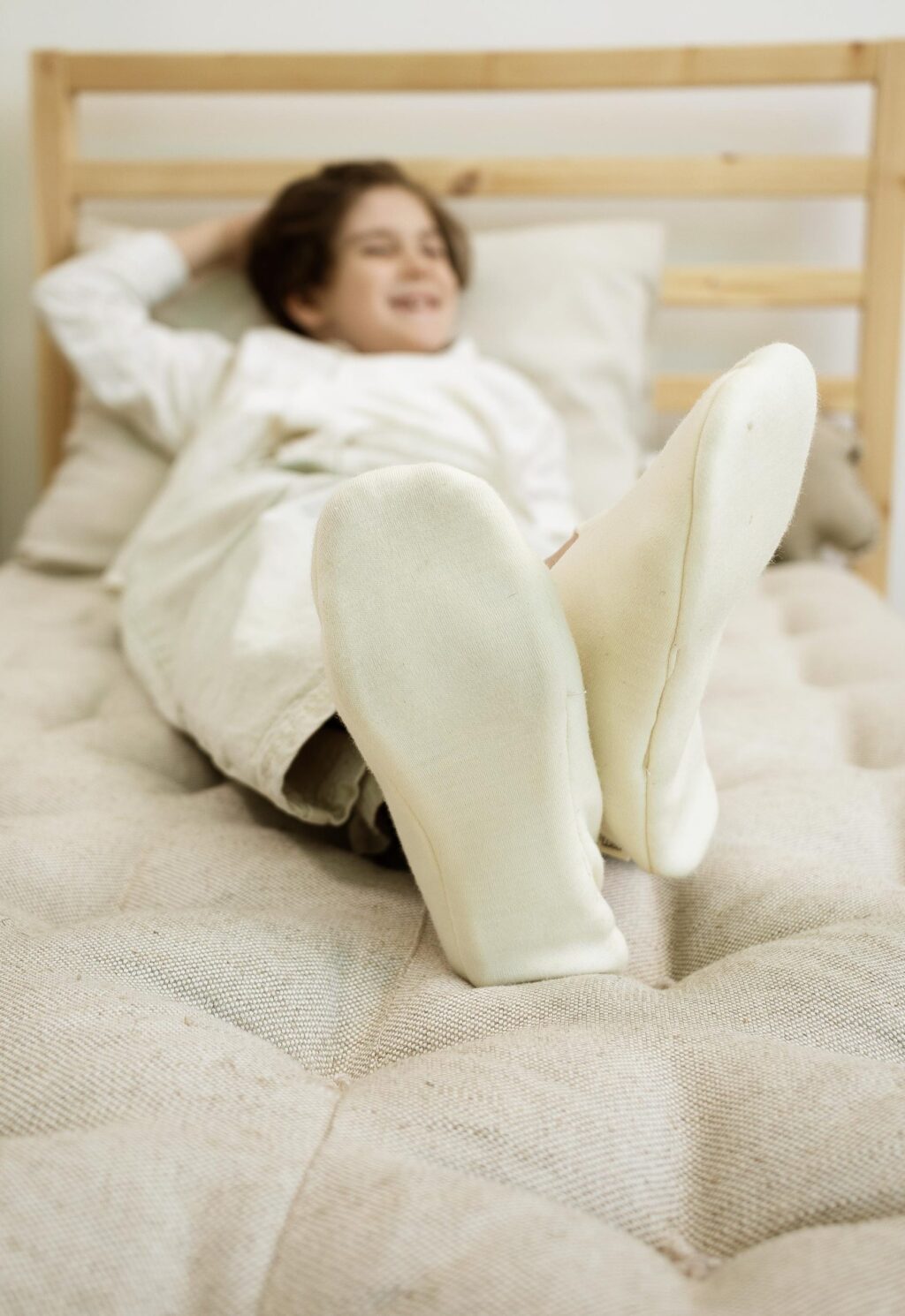 garçon heureux se relaxant sur un matelas en laine zéro déchet